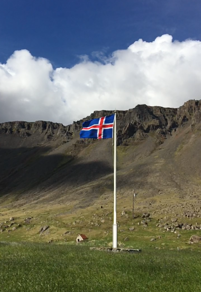 Icelandic flag waving in the wind in the Westfjords of Iceland