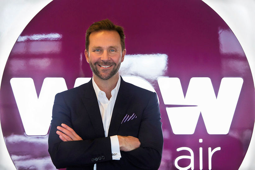 Skúli Mogensen, founder of WOW Air, posing in front of the airline's logo. All Things Iceland podcast.